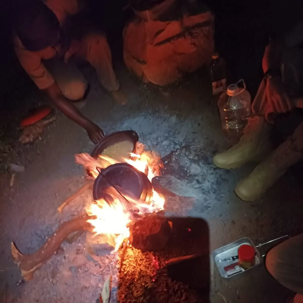 Ranger cucinano all’aperto intorno a un fuoco durante una missione notturna.