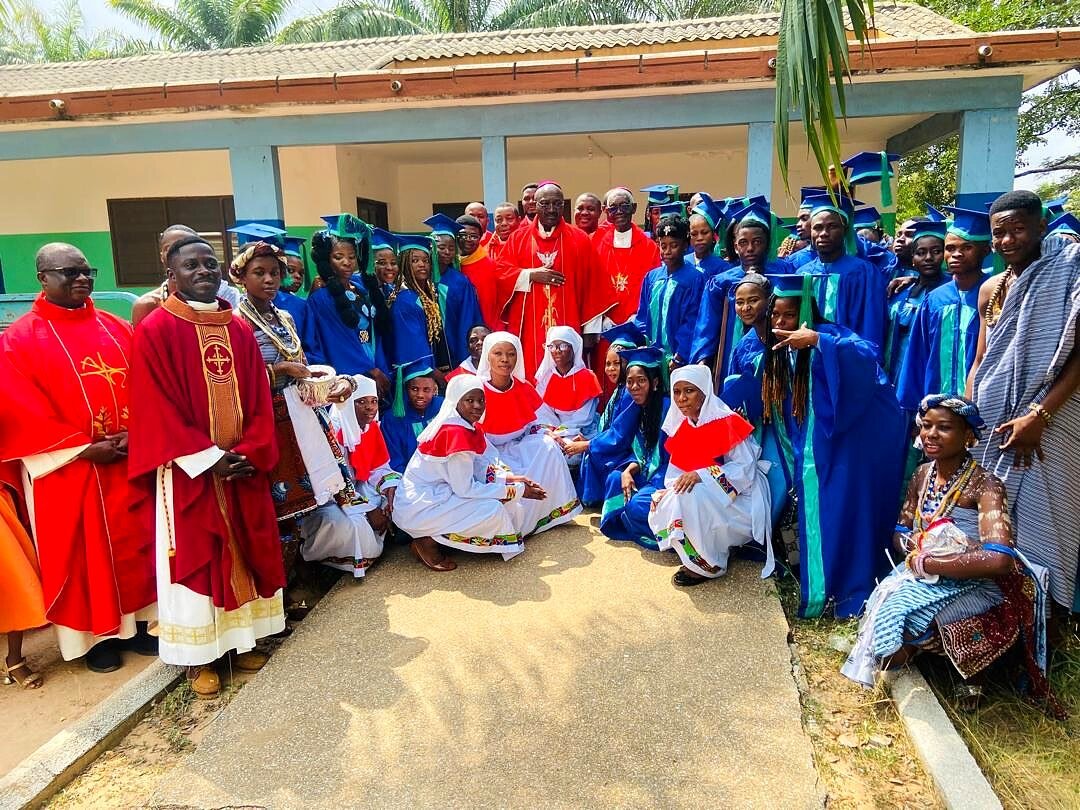 Celebrazione nel cortile del centro con sacerdoti e ragazzi in toga.