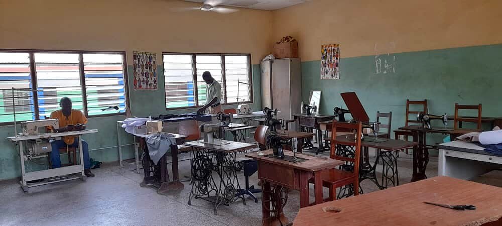 Laboratorio di sartoria con macchine da cucire a pedale.